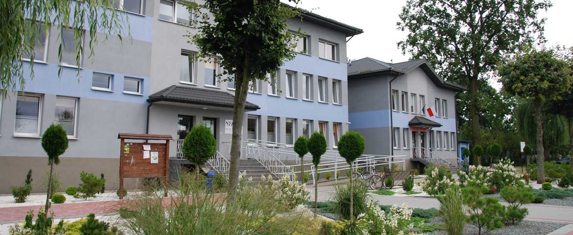 Widok budynku Urzędu Gminy w Gomunicach wraz otaczającą zielenią